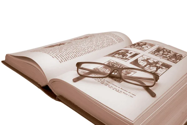 Старая книга и очки на белом — стоковое фото