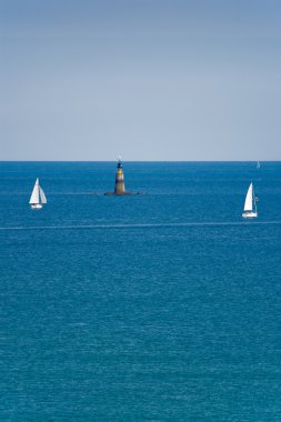 Two sailboats and a lighthouse clipart