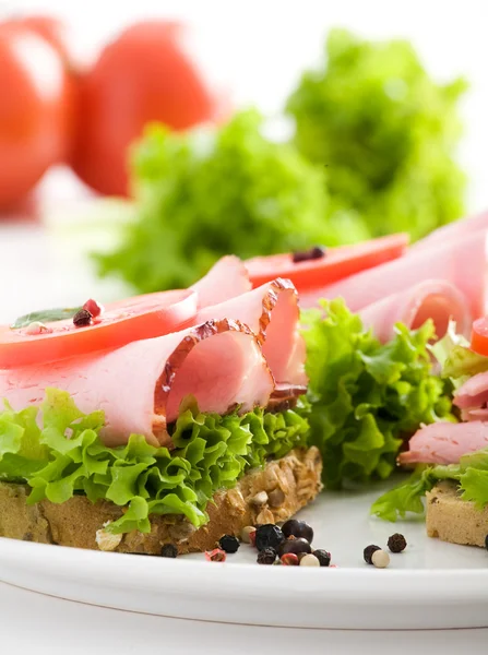Смачний бутерброд з шинкою, салатом і томом — стокове фото
