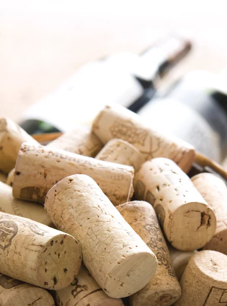 Corchos junto a la botella de vino tinto — Foto de Stock
