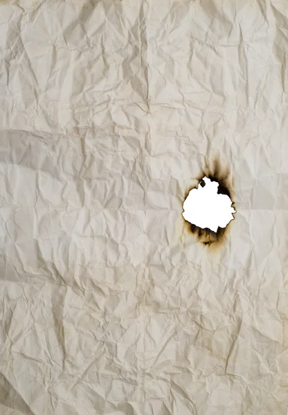 Buraco queimado no papel enrugado — Fotografia de Stock