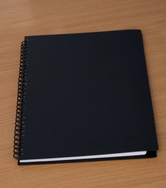 Spiral notebook on a table clipart