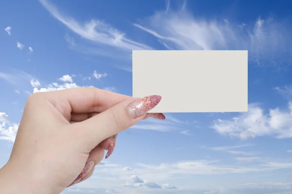Gökyüzü arka plan üzerinde elinde kart — Stok fotoğraf