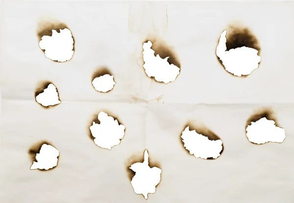 Verbrande gaten in een papier — Stockfoto
