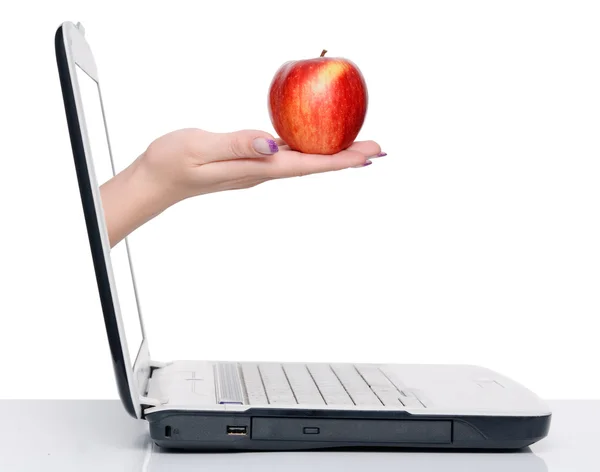Hand with apple and laptop — Stock Photo, Image