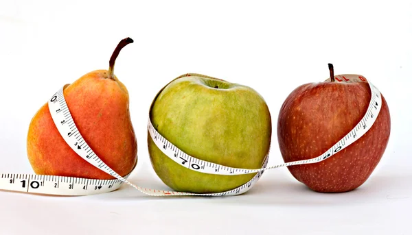 A pear and apples with measuring tape — Stock Photo, Image