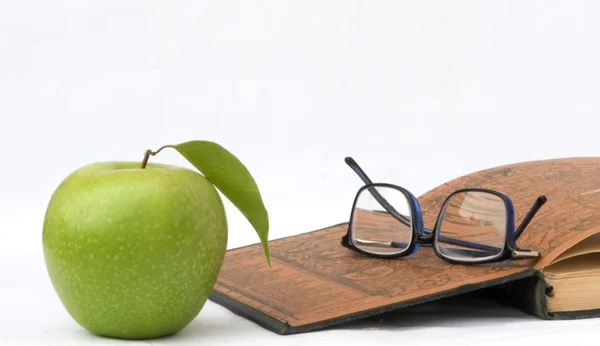 Apple, glasses and open book — Stock Photo, Image