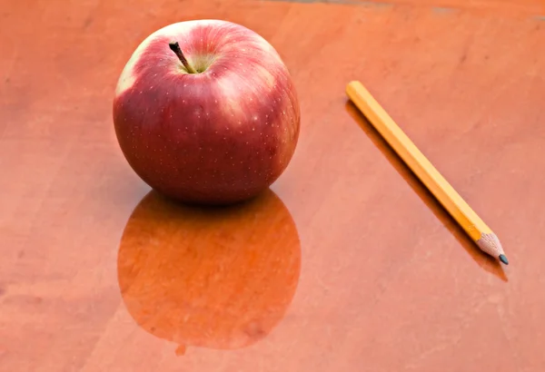 Elma ve kalem masada — Stok fotoğraf