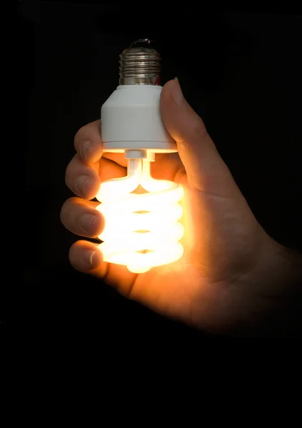 Az energiatakarékos lámpa a kezében — Stock Fotó