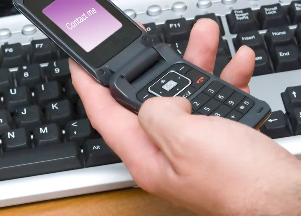 Telefone celular e teclado do computador — Fotografia de Stock