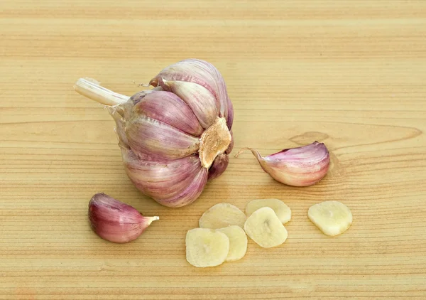 Garlic and cloves on desk — Stock Photo, Image