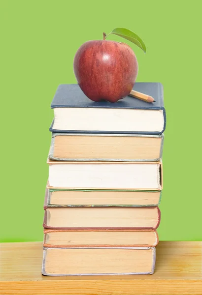Manzana roja y lápiz en un montón de libros — Foto de Stock