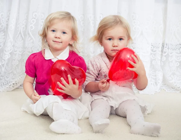 Две девушки с сердечными шариками — стоковое фото