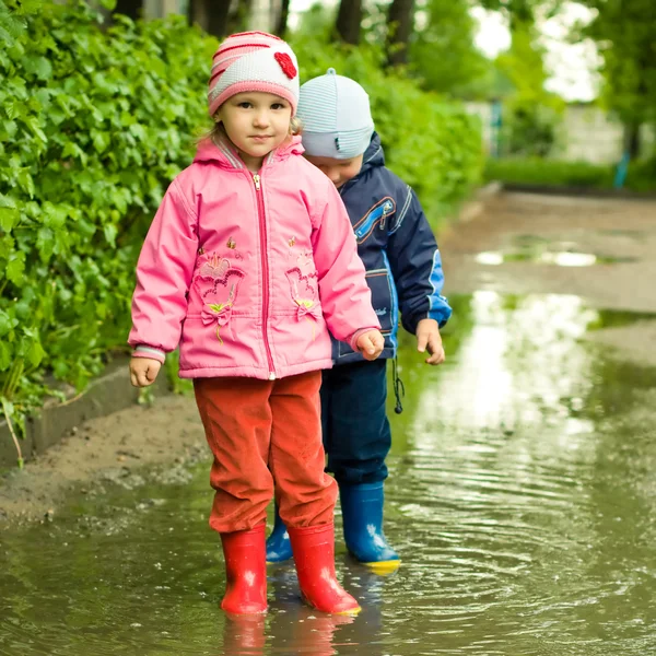 男孩和女孩在水坑里 — 图库照片