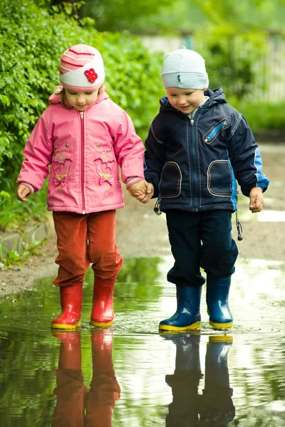 Boy and girl in the puddle — Stock Photo, Image