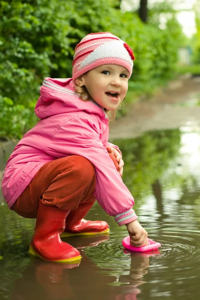 女孩玩船在水坑里 — 图库照片