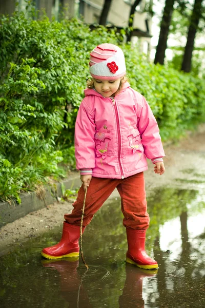 女孩扮演在水坑里 — 图库照片