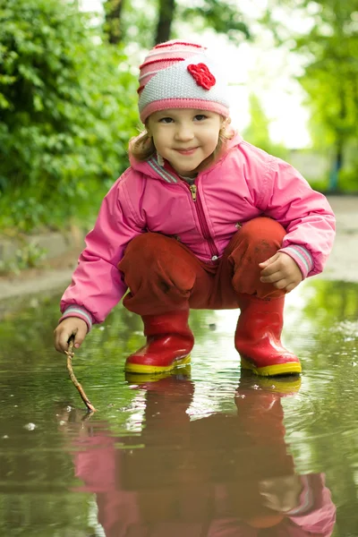 Girl plays in the puddle — Stock Photo, Image