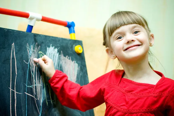 Dívka se kreslí s křídou na tabuli — Stock fotografie