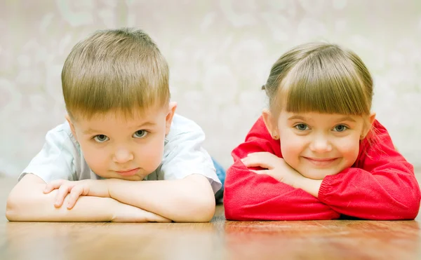 Забавный мальчик и девочка лежат на полу — стоковое фото