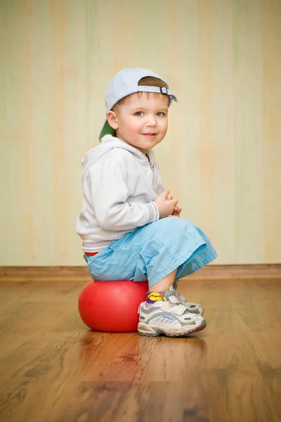 男孩坐在一个球上 — 图库照片