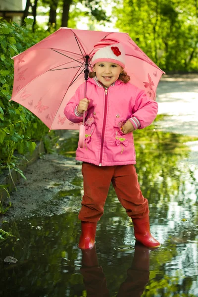 Dziewczyna w kałuży z parasolem — Zdjęcie stockowe