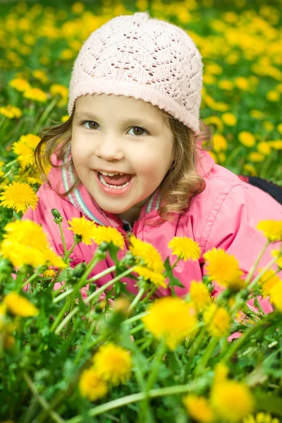 Funny girl in dandelions — Stock Photo, Image