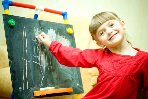 Girl draws with chalk on the blackboard Stock Photo