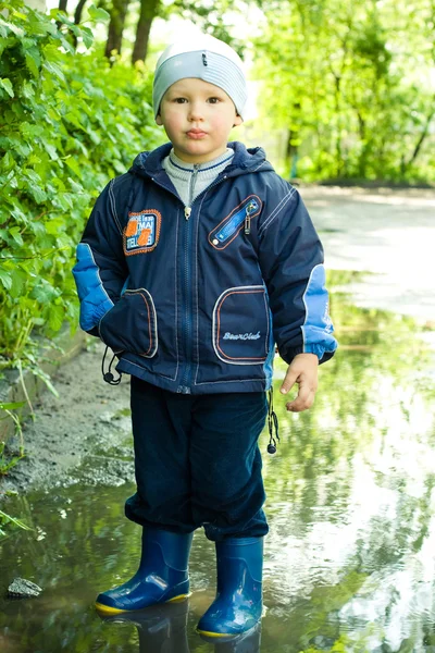 Маленький мальчик в луже — стоковое фото