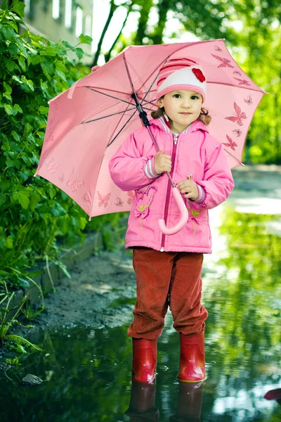 Lány ott áll a pocsolya, esernyő — Stock Fotó