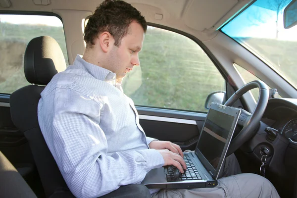 Laptop behind steering wheel — Stock Photo, Image