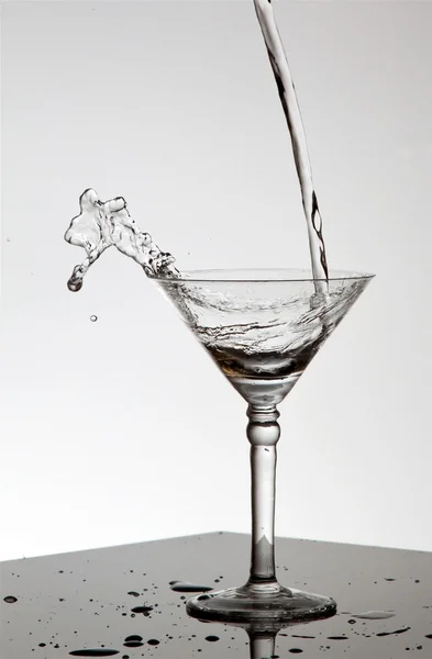 Víz ömlött a martini pohár — Stock Fotó