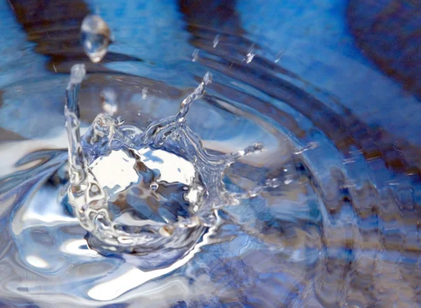 Kapka vody na modrém povrchu — Stock fotografie
