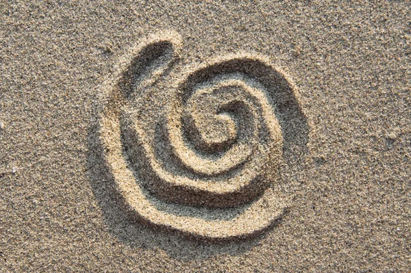 Знак спирали в песке — стоковое фото