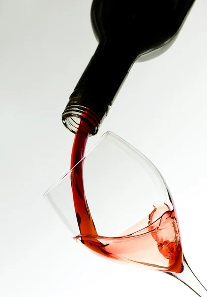 Wine glass and wine puring from bottle — Stock Photo, Image