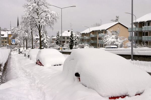 Parked cars buried under snow