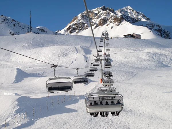Ski chair-lift with skiers — Stock Photo, Image