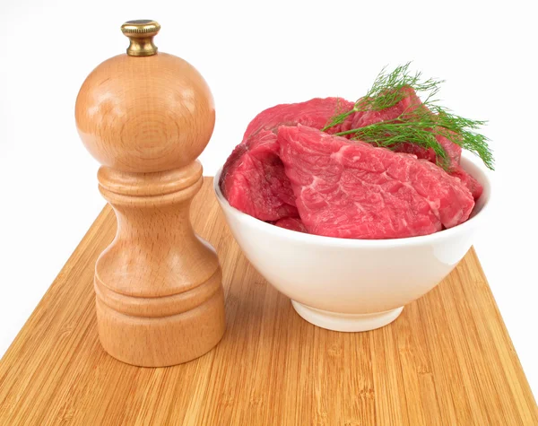 Fresh raw beef and pepper mill — Stock Photo, Image