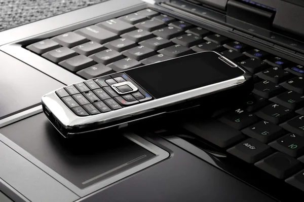 Smartphone em um laptop — Fotografia de Stock