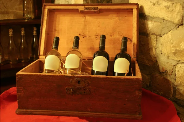 Quattro bottiglie di vino in una scatola di legno in — Foto Stock