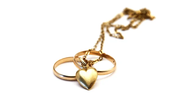 Anéis de casamento e coração dourado — Fotografia de Stock