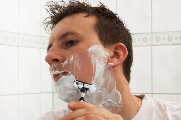 Young man is shaving — Stock Photo, Image