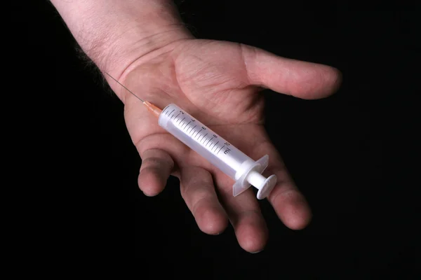 Homem segura injeção na palma da mão — Fotografia de Stock