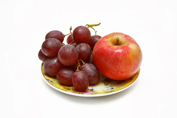 Grapes and apple on the plate — Stock Photo, Image