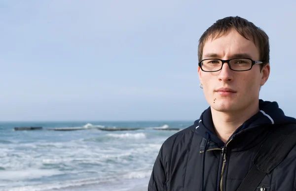Young handsome man in glasses against a — Stock Photo, Image