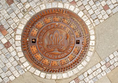 Closed manhole with emblem in Karlovy V clipart