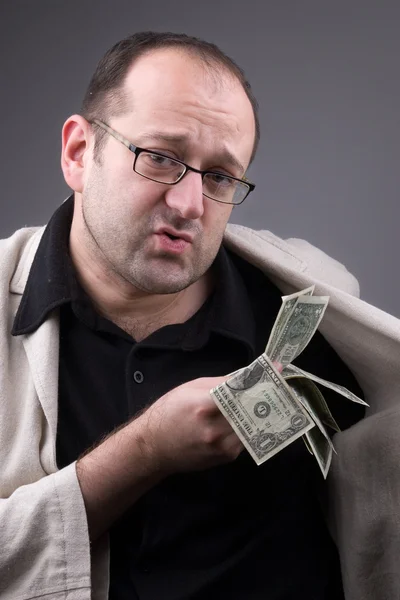 Zakenman zet geld op zak — Stockfoto