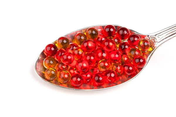 stock image Spoon with red and yellow capsules