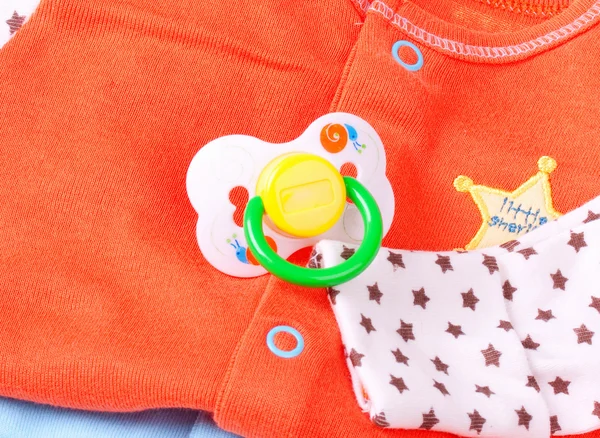 Fopspeen en baby kleding, close-up — Stockfoto