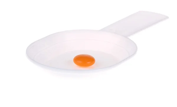 Pillola arancione su un cucchiaio di plastica bianca — Foto Stock